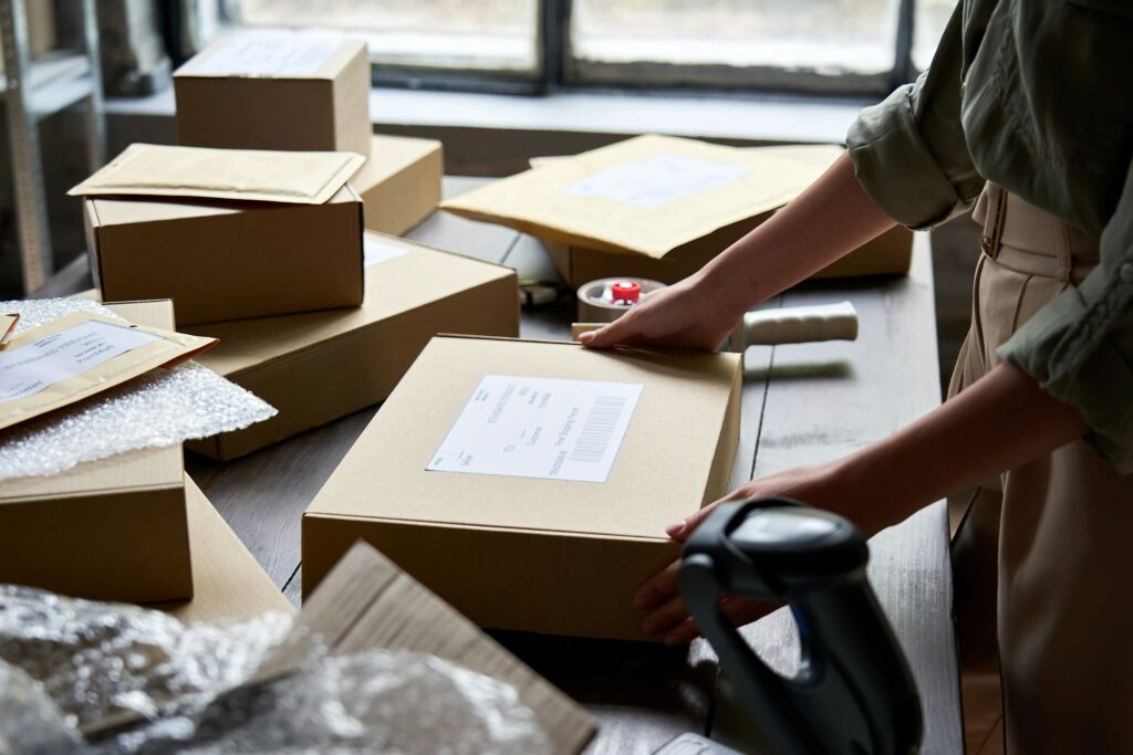 Female seller warehouse worker packing shipping order box for dispatching.