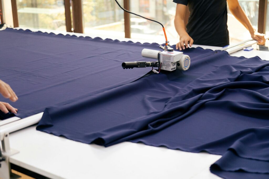 Person cutting fabric with machine